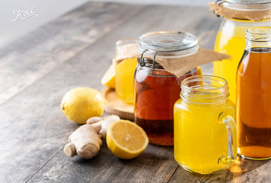 Glass jars and mason jars of golden kombucha with lemon and ginger on a rustic wooden table — 康普茶3大有機酸 · The 3 organic acids in kombucha